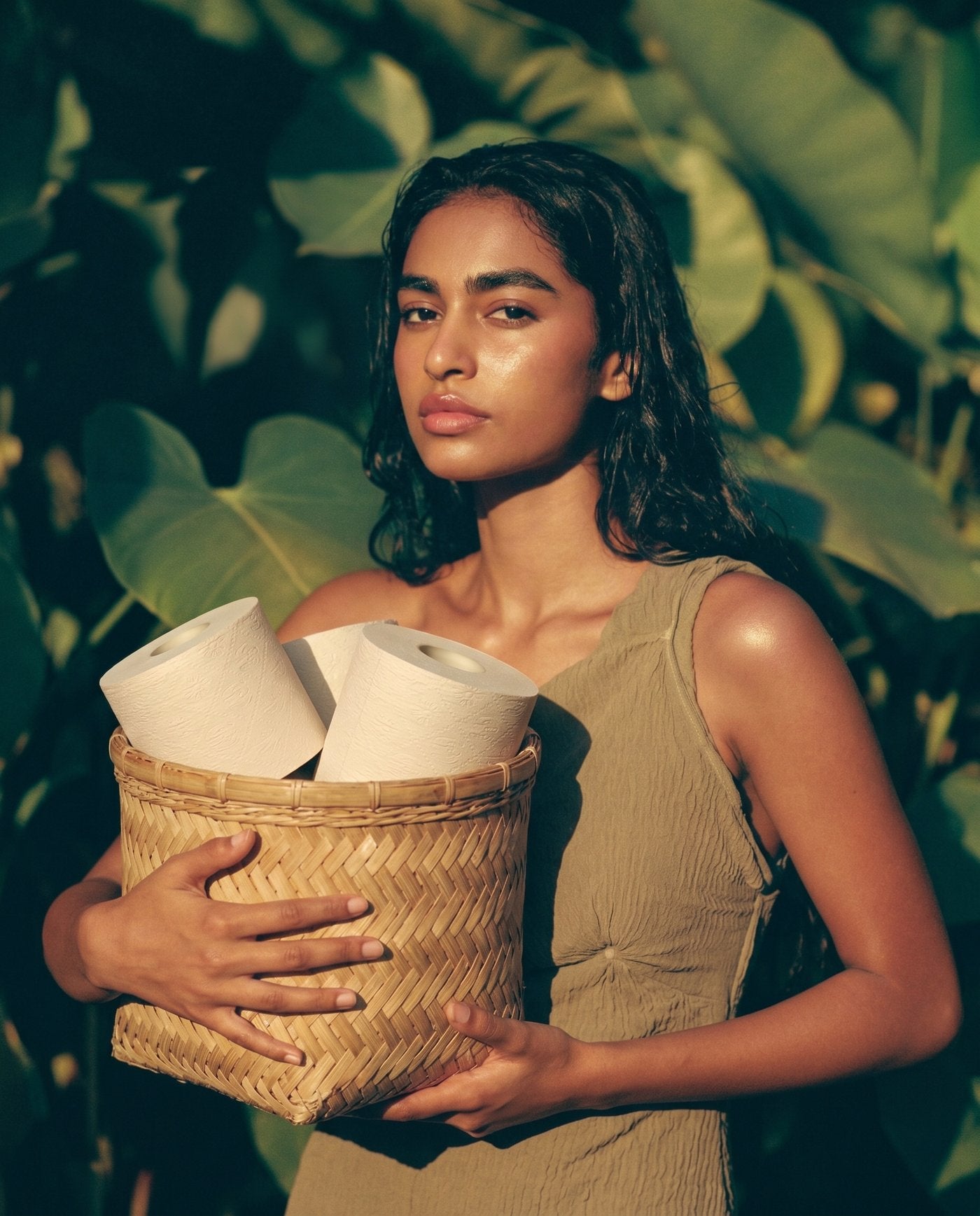 A woman holding an armful of cream rolls